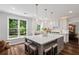 Bright open kitchen with a large center island, white cabinets, and a view to the backyard at 161 Forestview Dr, Suwanee, GA 30024