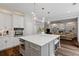 Bright kitchen featuring a marble island with bar stool seating and white cabinetry at 161 Forestview Dr, Suwanee, GA 30024