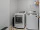 Functional laundry room with washer, dryer, overhead shelf, and tiled flooring at 161 Forestview Dr, Suwanee, GA 30024