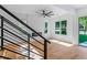 Open-concept living room features hardwood floors, black iron staircase and modern windows at 1835 Taylor Ave, East Point, GA 30344