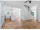Open floor plan with hardwood floors leading to a modern kitchen, staircase, and backyard access at 1835 Taylor Ave, East Point, GA 30344