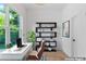 Staged office space with a large window, white desk, ergonomic chair and modern black bookshelf at 1835 Taylor Ave, East Point, GA 30344