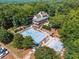 Aerial view of a large community pool with a spacious sundeck and surrounding lush landscaping at 3845 Overlake Dr, Cumming, GA 30041