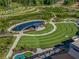 A scenic aerial view of the community's outdoor amphitheater, pond, and walking trail offers a tranquil living experience at 3845 Overlake Dr, Cumming, GA 30041