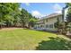 Spacious backyard with lush green grass and trees surrounding a two story home at 3845 Overlake Dr, Cumming, GA 30041