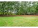 Grassy backyard with privacy fence and mature trees, offering a serene outdoor space at 3845 Overlake Dr, Cumming, GA 30041
