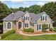 Charming home featuring manicured landscaping, stone accents, arched windows, and black shutters at 3845 Overlake Dr, Cumming, GA 30041