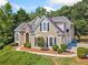 Charming home featuring manicured landscaping, stone accents, arched windows, and black shutters at 3845 Overlake Dr, Cumming, GA 30041