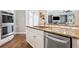 Kitchen island with granite counters, stainless steel dishwasher, and white cabinets at 3845 Overlake Dr, Cumming, GA 30041