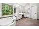 Bright bathroom features a soaking tub, a dual sink vanity, and large window views at 3845 Overlake Dr, Cumming, GA 30041