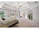 Bright main bedroom with tray ceiling, ample natural light, and a comfortable seating area at 3845 Overlake Dr, Cumming, GA 30041
