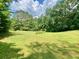 Vast, lush green backyard surrounded by trees, offering plenty of open space and natural beauty at 7680 Banks Mill Road Rd, Douglasville, GA 30135