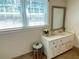 Bathroom with decorative mirror, vanity, stool, and window allowing for natural light at 7680 Banks Mill Road Rd, Douglasville, GA 30135