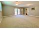 Large bedroom with neutral carpeting, bright lighting, and access to the backyard at 7680 Banks Mill Road Rd, Douglasville, GA 30135
