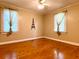 Bedroom featuring hardwood floors, neutral walls, and bright natural light from the two windows with coverings at 7680 Banks Mill Road Rd, Douglasville, GA 30135