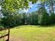 Expansive field with a rustic barn surrounded by lush greenery at 7680 Banks Mill Road Rd, Douglasville, GA 30135