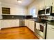 Traditional kitchen featuring white cabinetry, stainless steel appliances, and hardwood flooring at 7680 Banks Mill Road Rd, Douglasville, GA 30135