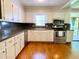 Traditional kitchen featuring white cabinetry, stainless steel appliances, and hardwood flooring at 7680 Banks Mill Road Rd, Douglasville, GA 30135