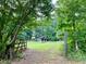 Picturesque property featuring a green lawn, mature trees, and a rustic outbuilding, offering serene views at 7680 Banks Mill Road Rd, Douglasville, GA 30135