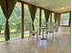 Bright sunroom with views of the backyard, tile flooring, and neutral-toned curtains at 7680 Banks Mill Road Rd, Douglasville, GA 30135