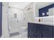 Bathroom with a glass shower, blue vanity, white marble floors, and accent lighting at 860 Peachtree St # 1103, Atlanta, GA 30308