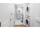 Hallway view of the modern bathroom and a stacked white washer and dryer at 860 Peachtree St # 1103, Atlanta, GA 30308
