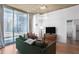 Light-filled living room with hardwood floors, city views, and modern lighting at 860 Peachtree St # 1103, Atlanta, GA 30308
