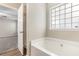 Soaking tub in main bathroom with natural light and neutral decor at 7420 Bristol Cir, Douglasville, GA 30134