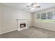 Bright carpeted bedroom features a fireplace, ceiling fan, and window for natural light at 7420 Bristol Cir, Douglasville, GA 30134