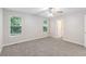 Bright bedroom features neutral carpet, a ceiling fan, and natural light from large windows at 7420 Bristol Cir, Douglasville, GA 30134