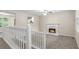 Carpeted living room on second level with white fireplace and staircase with white railings at 7420 Bristol Cir, Douglasville, GA 30134