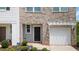 Close-up of a charming townhome featuring a front door, one car garage, and a well-manicured front yard at 161 Swindon Dr, Mcdonough, GA 30253