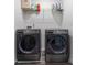 Laundry room featuring front load washer and dryer and a wire shelf with laundry supplies above at 161 Swindon Dr, Mcdonough, GA 30253