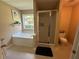 Bright bathroom featuring a soaking tub, glass enclosed shower, and natural light at 345 Annslee Circle Cir, Loganville, GA 30052