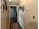 Long hallway with wooden floors, framed art, and neutral paint, offering a seamless transition between rooms at 345 Annslee Circle Cir, Loganville, GA 30052
