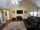 Cozy living room featuring a vaulted ceiling, large TV, leather sofa, and ample natural light at 345 Annslee Circle Cir, Loganville, GA 30052