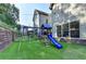 Backyard features a playground, string lights, artificial turf, and a black fence at 4335 Bellview Ln, Duluth, GA 30097