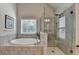 Bright bathroom with a luxurious soaking tub, tiled walls and a glass-enclosed shower at 4335 Bellview Ln, Duluth, GA 30097