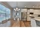 Cozy dining area featuring a long wooden table, stylish light fixture, and stainless steel appliances at 4335 Bellview Ln, Duluth, GA 30097