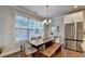 Bright dining area with a large window, modern light fixture, and stainless steel refrigerator at 4335 Bellview Ln, Duluth, GA 30097