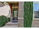 Close-up of a brick home's front door with a glass panel, side shrubs and security camera at 4335 Bellview Ln, Duluth, GA 30097