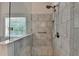 Close up of walk in shower with glass and marble tiled walls at 4335 Bellview Ln, Duluth, GA 30097