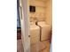 Functional laundry area with white washer and dryer, shelving, and neutral flooring at 979 Simonton Glen Dr, Lawrenceville, GA 30045