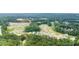 Aerial view of a real estate community with winding roads and new construction surrounded by lush greenery and trees at 114 Crooked Lake Park, Villa Rica, GA 30180