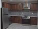 Modern kitchen with stainless steel appliances, granite countertops, stylish backsplash and dark wood cabinets at 1417 Pineglen Dr, Riverdale, GA 30296