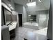 This bathroom features dual sinks, a glass shower, a garden tub, and a skylight for ample natural light at 2550 Lynshire Ln, Snellville, GA 30078