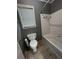Cozy bathroom featuring a tiled shower-tub, toilet, and window with blinds at 2550 Lynshire Ln, Snellville, GA 30078