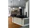 A kitchen island featuring black countertops, decorative lighting, and a sink at 2550 Lynshire Ln, Snellville, GA 30078
