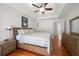 Spacious bedroom with a tray ceiling, a ceiling fan, hardwood floors, and a wooden bed frame at 2775 Harper Ferry Dr, Lawrenceville, GA 30044