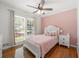 Cozy bedroom with a window letting in lots of natural light, hardwood floors, and pink accent wall at 2775 Harper Ferry Dr, Lawrenceville, GA 30044